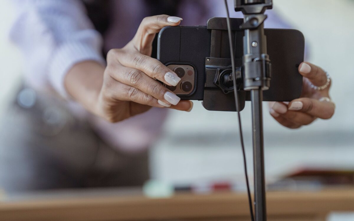 Woman recording a video with a phone on a tripod